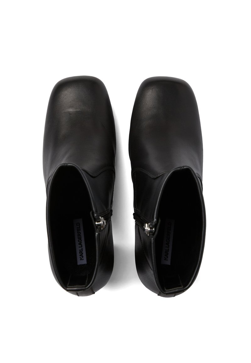 Zwarte leren enkellaarsjes met een gladde afwerking, vierkante neus en ritsen aan de zijkant, met een minimalistisch design en een intern merketiket.