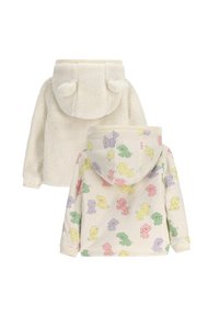Kremowy polarowy hoodie z uszkami misia; strona odwrotna ma pastelowe nadruki z rysunkami psów na jasnym tle. Miękka tekstura, luźny krój.