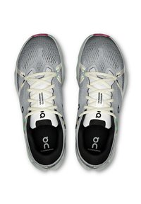 Lichtgrijze sport schoenen met een gewoven mesh bovenwerk, witte veters en een roze accent op de teen. Heeft een gewatteerde zwarte binnenzool.
