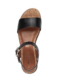 Sandale en cuir noir avec large sangle, semelle en liège et intérieur de pied marron. Boucle de cheville réglable pour un ajustement sécurisé. Détail en logo doré sur l'intérieur de pied.