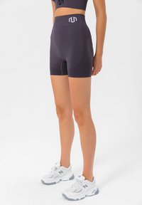 Hochtaillierte, dunkelviolette Sportshorts aus strukturiertem Material, mit einem Logobund und seitlichen Akzenten für eine konturierte Passform.