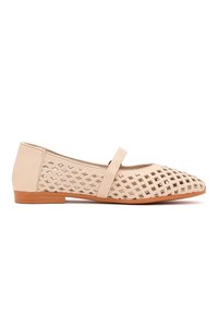 Beige platte schoen met een gaasachtige uitsnijdingspatroon, een enkele bovenband en een lage houten hak.