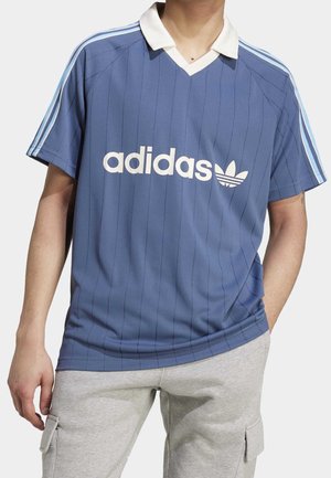 Maillot bleu Adidas avec des rayures verticales, col blanc et logo. Manches courtes avec des accents bleus sur les épaules. Design décontracté.