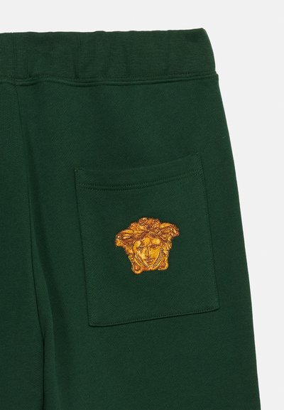 Σκούρες πράσινες φόρμες με τσέπη-μπατζ που διαθέτει κεντητό χρυσό σχέδιο κεφαλής Μέδουσας.