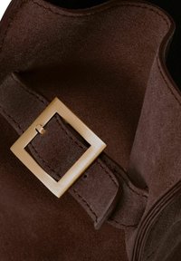 Brązowy zamsz o gładkiej fakturze, z złotą kwadratową sprzączką i starannym przeszyciem wzdłuż paska.