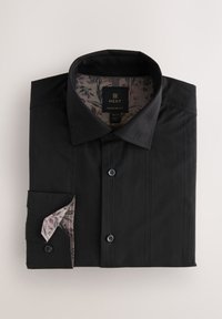 Schwarzes, langärmliges Hemd mit dezenten vertikalen Streifen, ordentlich gefaltet, zeigt das floral gemusterte Innenfutter von Kragen und Manschetten.