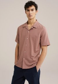 Camicia a maniche corte con colletto in rosa polveroso, realizzata in tessuto morbido, con bottoni sul davanti e una vestibilità comoda.