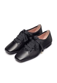 Scarpe in pelle nera con punta quadrata, caratterizzate da lacci in satin sottili e una superficie liscia, accentuata da minimi dettagli di cucitura.