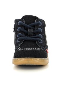 Scarpa in suede nera con lacci blu, punta rotonda, cuciture bianche e suola in gomma. Il lato presenta un piccolo dettaglio rosso.