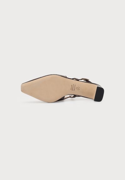 Chaussure habillée noire à bout pointu pour femme, vue de la semelle, dessous beige, talon bloc et bride de cheville avec boucle visible.