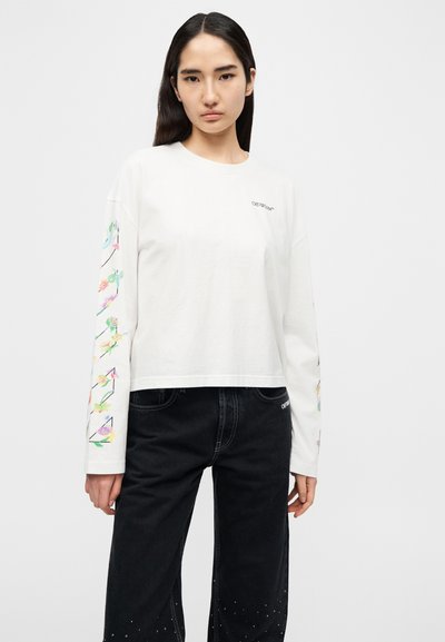 Λευκό κοντό μπλουζάκι με μακριά μανίκια και floral σχέδιο στα μανίκια· υλικό από υψηλής ποιότητας βαμβάκι με στρογγυλή λαιμόκοψη και κεντημένη λεπτομέρεια με λογότυπο.