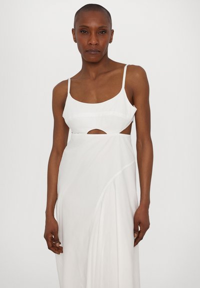 Vestido blanco con un corsé ajustado, tirantes finos, un corte en la cintura y falda fluida. Fabricado con un tejido ligero y suave.