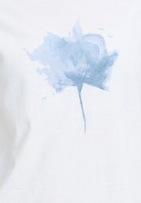 Fleur bleu clair de style aquarelle avec tige sur un fond en tissu blanc, ressemblant à un imprimé floral sur des vêtements.