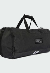 Black duffel bag made of textured fabric with a glossy black bottom, featuring a logo patch and white accent stripes. Two sturdy handles.