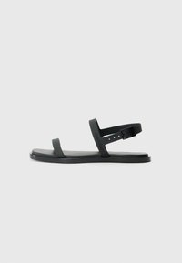 Black plastic sandals with two flat straps and a buckle closure. Features a textured footbed and a minimalist design.