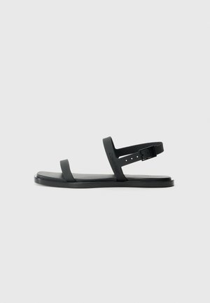 Sandalias de plástico negro con dos correas planas y cierre de hebilla. Cuenta con una base texturizada y un diseño minimalista.