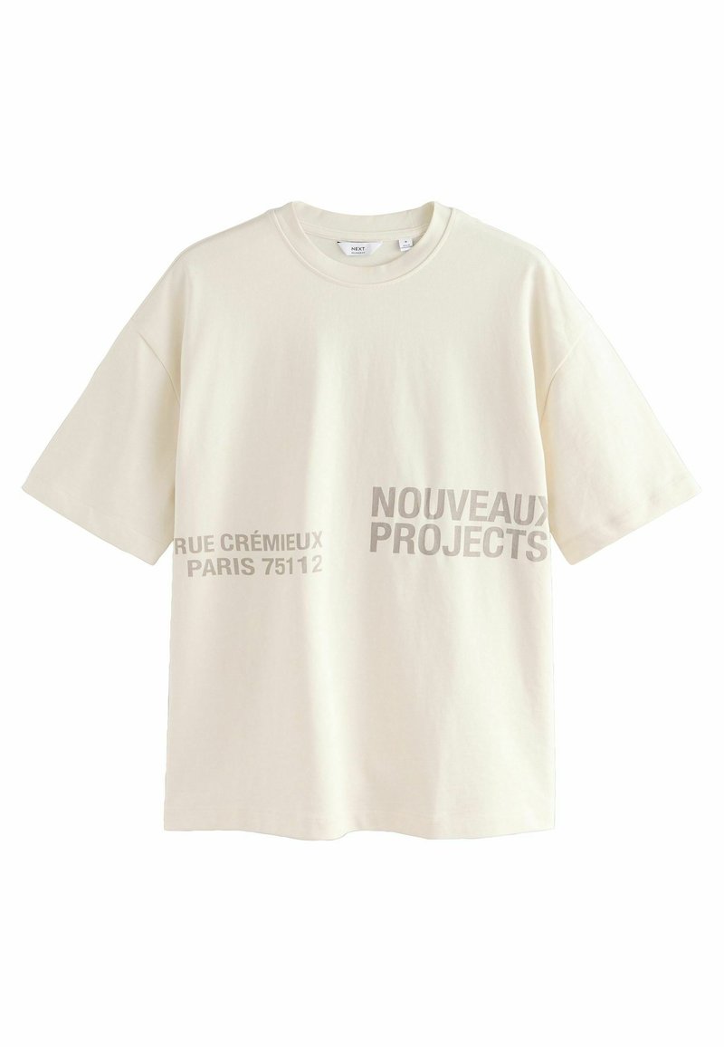 Camiseta de manga corta en color crema claro, hecha de algodón, con texto gris que dice "NOUVEAUX PROJECTS" y "RUE CRÉMIEUX PARIS 75112" impreso en la parte frontal.