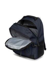 Granatowy plecak wykonany z trwałej tkaniny, z dużym otworem oraz jasnoszarym wnętrzem z czarnymi akcentami i zamkiem na suwak.