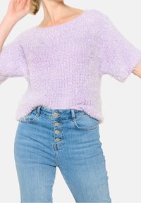 Purppuru no fujī nitto seetā wa hiroi bōto nekkura to mijikai shību ga tsuiteimasu, takai ueshi no aoi denimu jīnzu to kumikomi, boton furoontok�ōkisei ga arimasu.