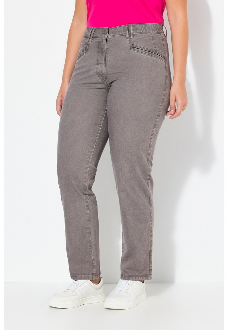 Graue Jeans im geraden Schnitt mit Fronttaschen, dezenten Nähten und kombiniert mit weißen Sportschuhen.