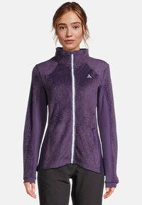 Giacca in pile viola con colletto alto, tessuto allantico e zip a contrasto. Ha maniche lisce e un logo sul petto.