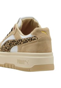 Sneaker con una toma in suede beige, dettagli in pelle bianca, striscia a stampa leopardata, collo imbottito e suola piatta color crema. Dettaglio del logo dorato.