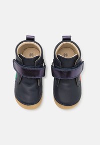 Chaussures en cuir marine avec une finition douce, dotées d'une large sangle en velcro violette et d'une semelle en caoutchouc beige. Comprend une étiquette de taille "20" à l'intérieur.