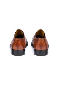 Chaussures en cuir marron avec une finition lisse et un bout arrondi, dotées d'une semelle en caoutchouc noir et de détails de couture minimaux.