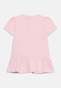 Ροζ κοντομάνικο φόρεμα με στρογγυλή λαιμόκοψη, κλείσιμο με κουμπιά στο πίσω μέρος και βολάν στο τελείωμα. Κατασκευασμένο από απαλό βαμβακερό ύφασμα.