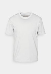 Vit bomull t-shirt med kort ärm, rundad halsringning och liten broderad logotyp på vänster bröst. Slät textur, minimalistisk design.