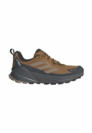 Brown and gray athletic shoe featuring a textured mesh upper, rubber sole, and contrasting stripes on the side. GORE-TEX branding visible.