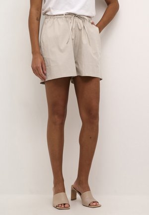 Shorts beige leggeri con vita elastica e cordoncino, dotati di tasche laterali e vestibilità comoda. Tessuto liscio con una texture morbida.