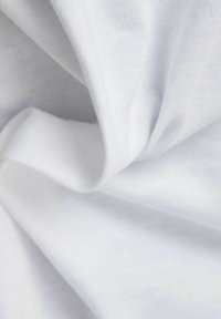 Tejido blanco suave, con una textura lisa y un ligero brillo, luciendo un aspecto arrugado que resalta sus cualidades de caída.