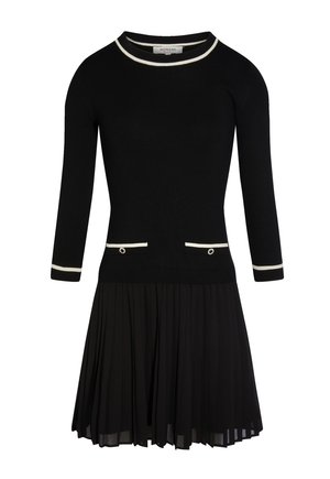 Schwarzes langärmliges Kleid mit weißem Besatz am Kragen und an den Manschetten, zwei vorderen Taschen mit Knöpfen und einem plissierten Rock.