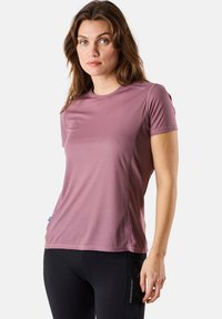 Short-sleeve, fitted athletic t-shirt in light mauve with textured fabric, subtle side seams, and logo detail near the shoulder.