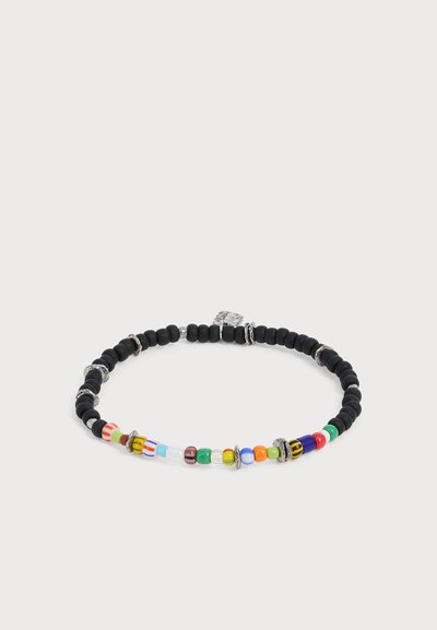 Bracelet rond à perles avec principalement des perles noires et une section de petites perles décoratives colorées et argentées sur fond blanc.