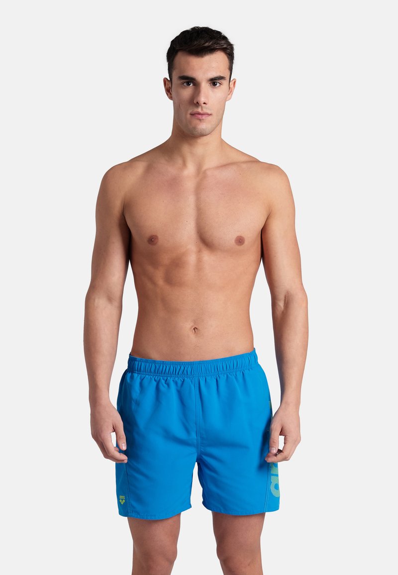 Pantaloni da bagno blu realizzati in un tessuto leggero, con vita elastica e un piccolo logo sul lato sinistro.