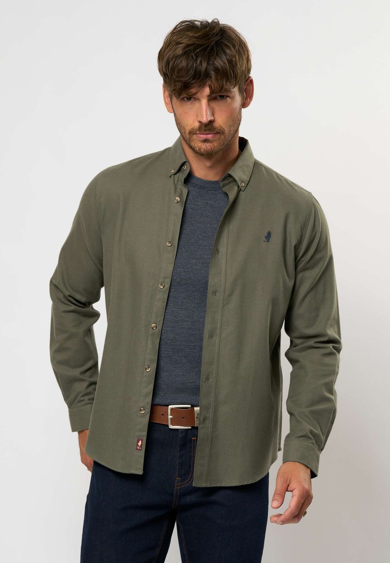 Camicia button-up verde oliva realizzata in tessuto intrecciato, con colletto classico, bottoni a contrasto e un piccolo logo ricamato sul petto.