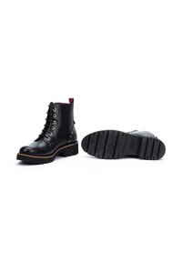 Black leather ankle boots with silver hardware, round toe, lace-up front, red accent at the top, and a textured rubber sole.