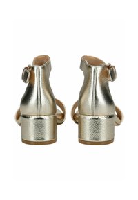 Goldfarbene, metallische Sandalen mit Absatz, die eine strukturierten Oberfläche, ein Knöchelriemen mit Schnalle und ein Blockabsatz-Design aufweisen.