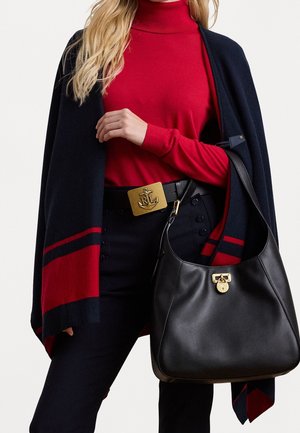 Femme portant un col roulé rouge, un châle rayé marine et rouge, un pantalon noir, une ceinture noire avec une boucle en forme d'ancre dorée, tenant un sac à main en cuir noir.