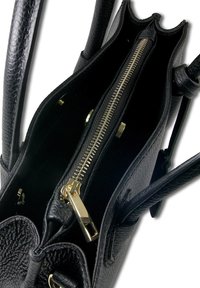 Zwarte leren handtas met een gestructureerde buitenkant, dubbele handvaten en een ritssluiting met gouden hardware. Het interieur toont vakken.