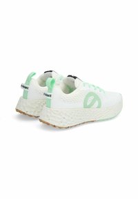 Witte sportieve schoenen met een gestructureerde bovenkant, mintgroene accenten, een dikke gespikkelde zool en zwarte details op de tong en hak.