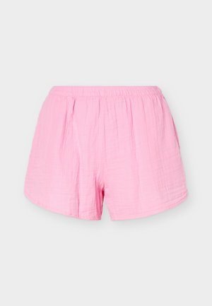 Ροζ βαμβακερά σορτς ανοιχτού χρώματος με ελαστική μέση και χαλαρή εφαρμογή, απεικονιζόμενα σε απλό φωτεινό φόντο.