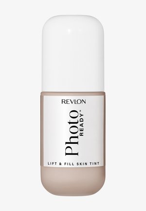Tinte para la piel Revlon PhotoReady Lift & Fill en tono beige con tapa y etiqueta blancas, diseñado para cubrir la piel y aportar luminosidad.