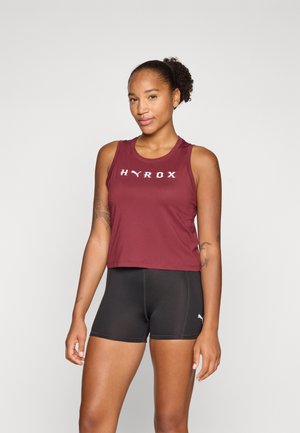 Maroon cropped tank top with white "HYROX" logo; paired with black fitted shorts. Smooth texture, sleeveless design, minimalist style.