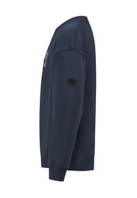 Sweat-shirt bleu marine à manches longues avec poignets et ourlet côtelés, comportant un petit patch logo noir sur le bras gauche.