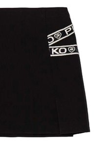 Minigonna nera con spacco laterale, bande decorative bianche e nere con logo, dal tocco morbido e dal design aderente.