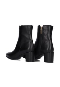 Zwarte leren enkelboots met een gladde textuur, ronde neus en een middelhoge blokhak. Voorzien van een zijrits.