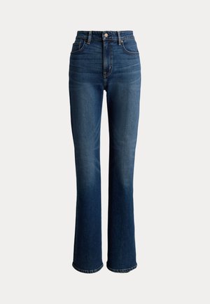 Τζιν ψηλόμεσο σε σκούρο μπλε με ελαφριά ξεθώριασμα, καμπάνες στα πόδια, πέντε τσέπες και λεπτομέρειες με εξαρτήματα σε χρυσή απόχρωση.